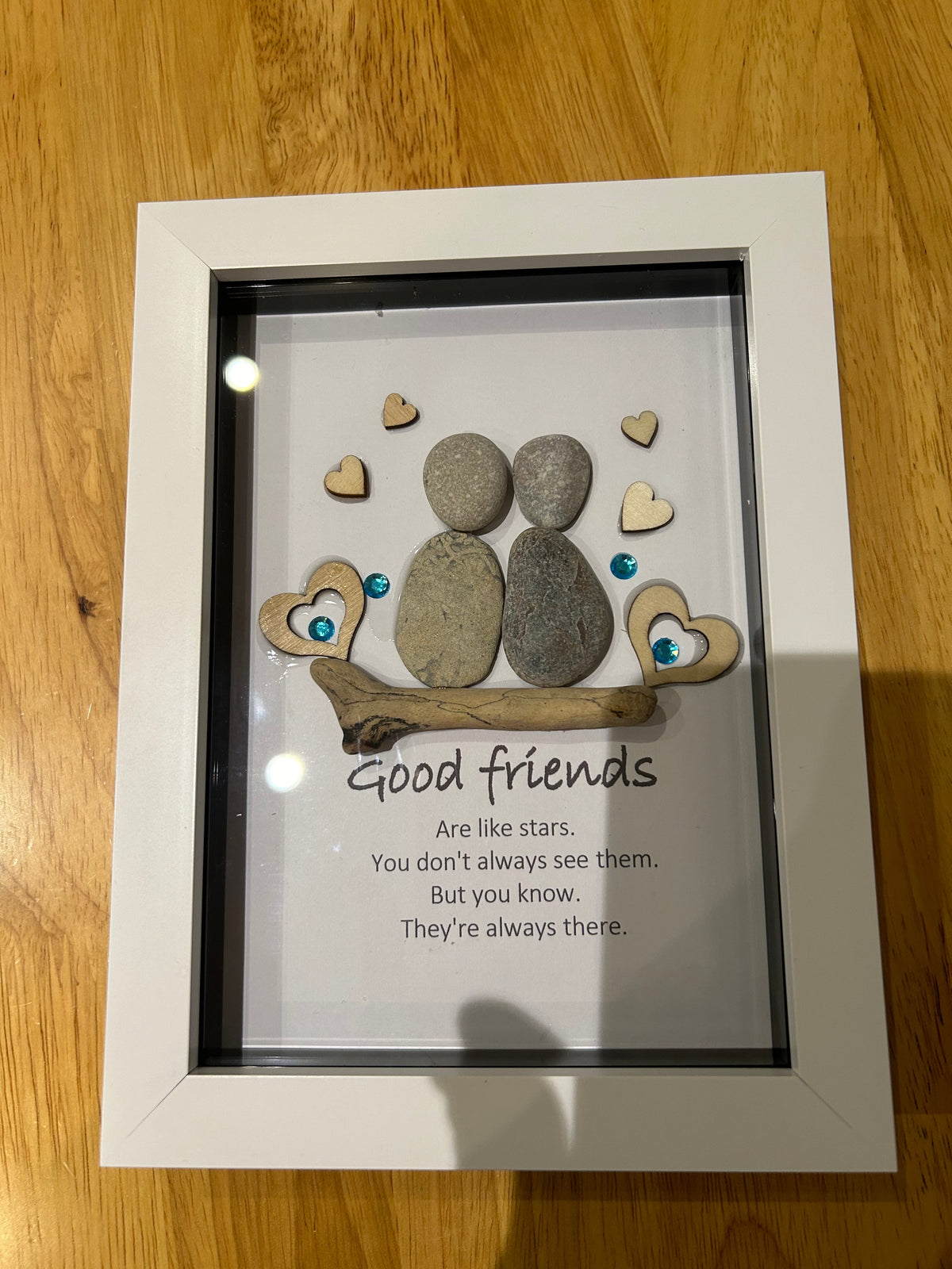 Two pebble friends on driftwood with wooden hearts and teal gems, good friends are like stars quote shadow box frame