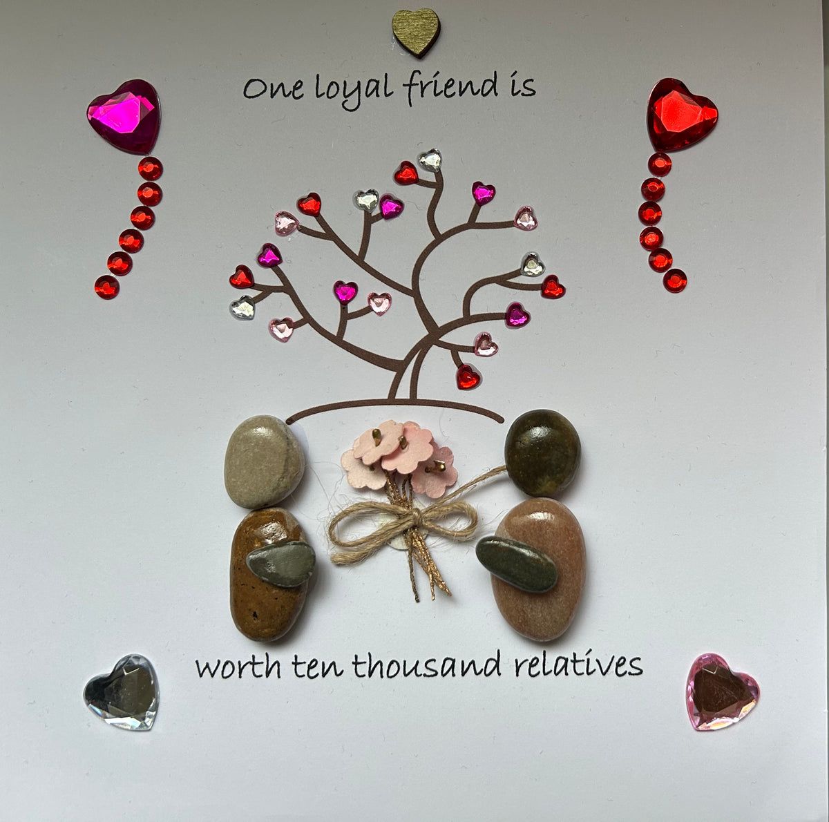 Two pebble friends beneath a love tree with gem hearts and floral bouquet, friendship quote frame