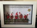 Five robins in Santa hats on a picket fence pebble art frame