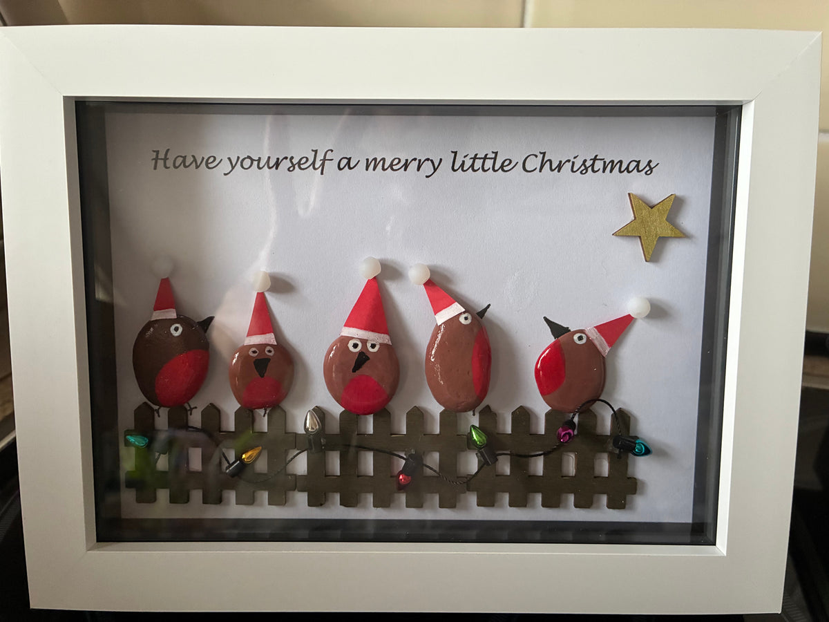 Five robins in Santa hats on a picket fence pebble art frame