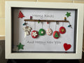 Handmade Christmas pebble art frame with painted pebbles and festive decorations